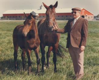 Charlie Armstrong, holding Armbro Auriel, at his 1,200-acre Caledon farm, where the office washroom are labelled 'mares' and 'studs.'