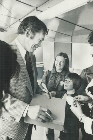 George Armstrong, coach of Memorial Cup champion Marlboros, signs autographs for admirers at civic reception for team at Nathan Phillips Square yesterday