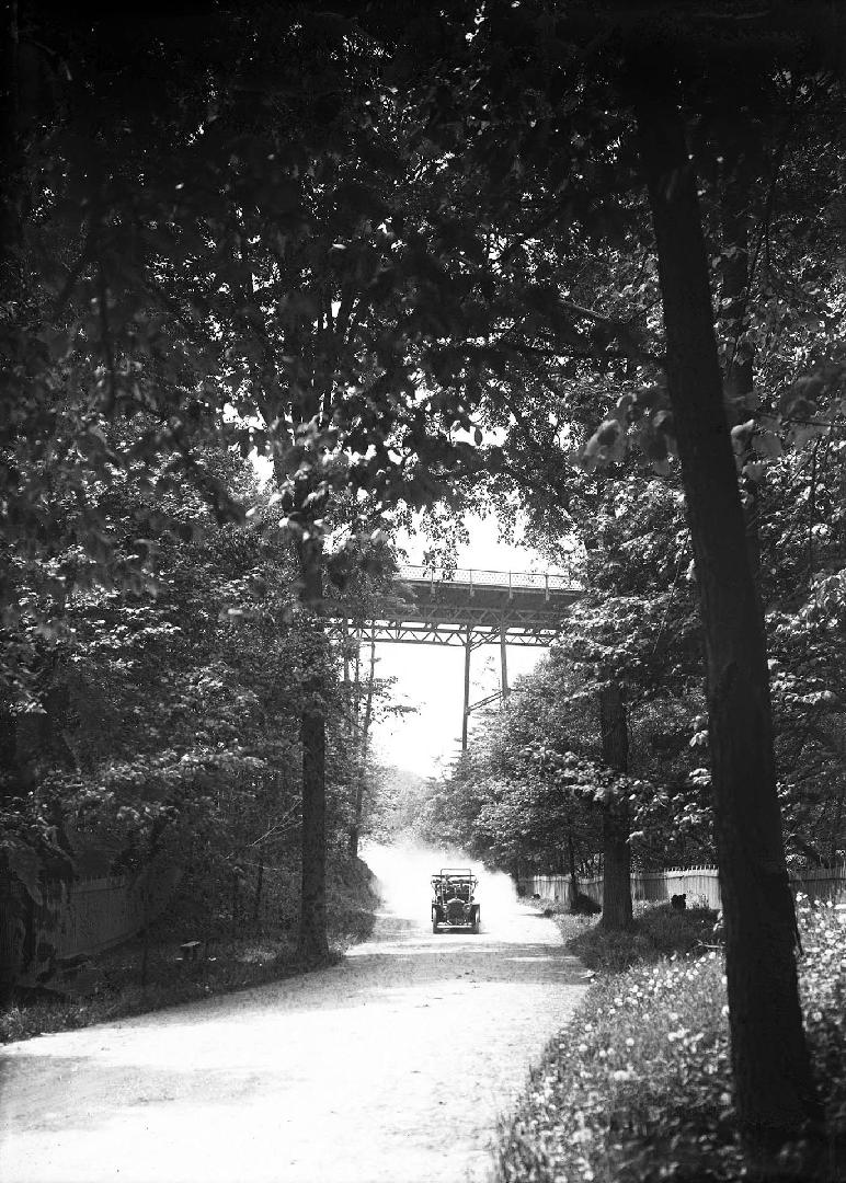 Image shows a road view with a bridge over it.