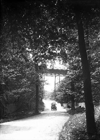 Image shows a road view with a bridge over it.