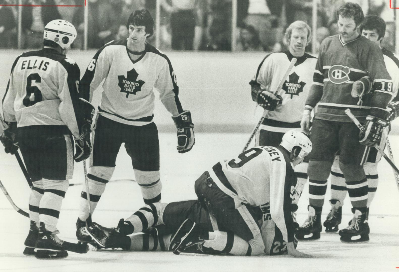 Leafs' Dan Maloney restrains teammate Tiger Williams as Habs' Larry Robinson looks on