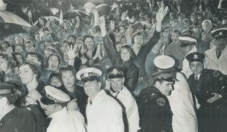 Forest of arms waves joyfully in rain at City Hall last night as Team Canada comes home