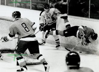 The downside: Luc Fillatrault of the Trois-Rivleres Patriotes finds himself in an awkward position along the boards after contact with Brandon's Reg Spence yesterday in hockey final at Varsity Arena