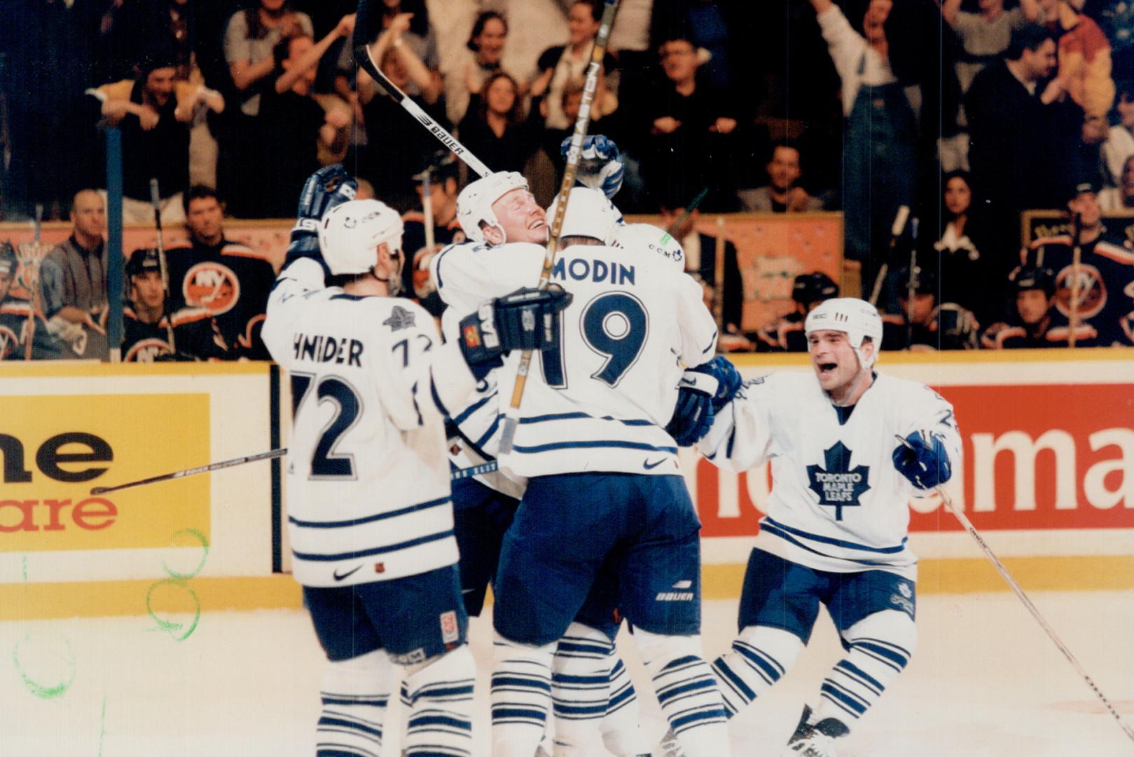 Quick impact: Leafs Mathieu Schneider, left, Mats Sundin, Fredrik Modin and Tie Domi mob Sylvain Cote, hidden, who scored OT winner at Maple Leaf Gardens last night