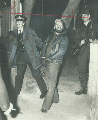 An unhappy Vagabond. Disgruntled member is led away after police raid last night on clubhouse of Vagabonds motorcycle club in east-end Toronto. Equipp(...)