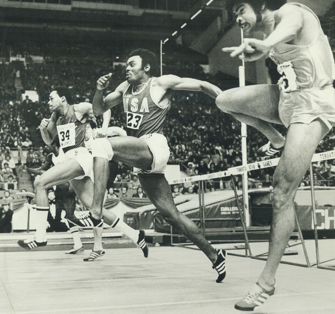 Strain of exertion showing on their faces, Dan Hill (left), and Willie Davenport, both of the U.S.