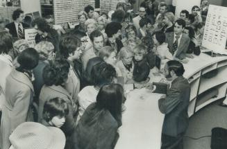 An angry crowd surrounds Remo Monti, an Eaton's manager at Scarborough Town Centre, as he explains at 9