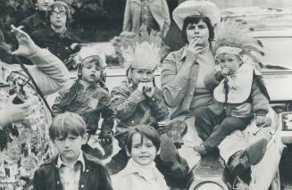 A cowgirl an her 'Indians' watch the action