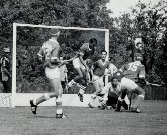 Hockey, Pan-Am style, Closing in on Jamaica net are Paul McMillen (12) and Bruce Hodgson (15) of Canadian hockey team