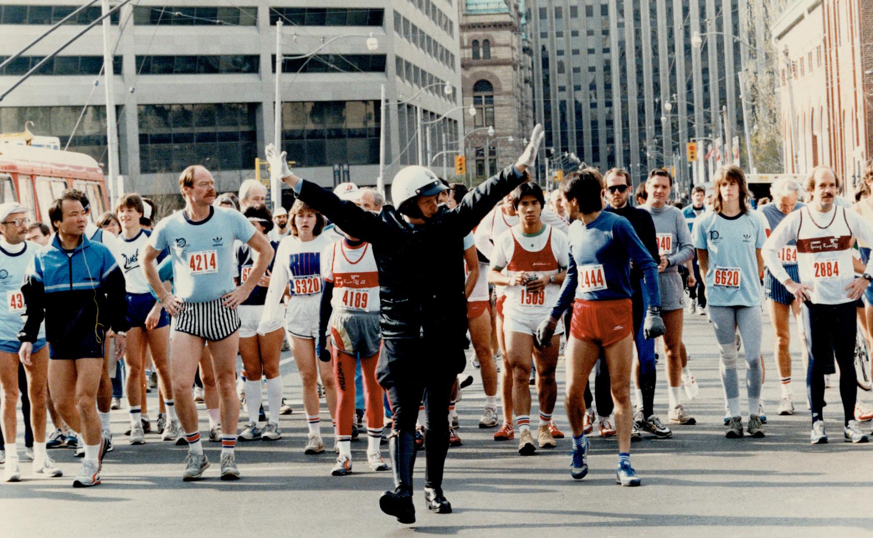 Now wait for the 'Walk' signal, A policeman does his best to direct a varied assortment of traffic about to set out from near City Hall on the Eaton 1(...)