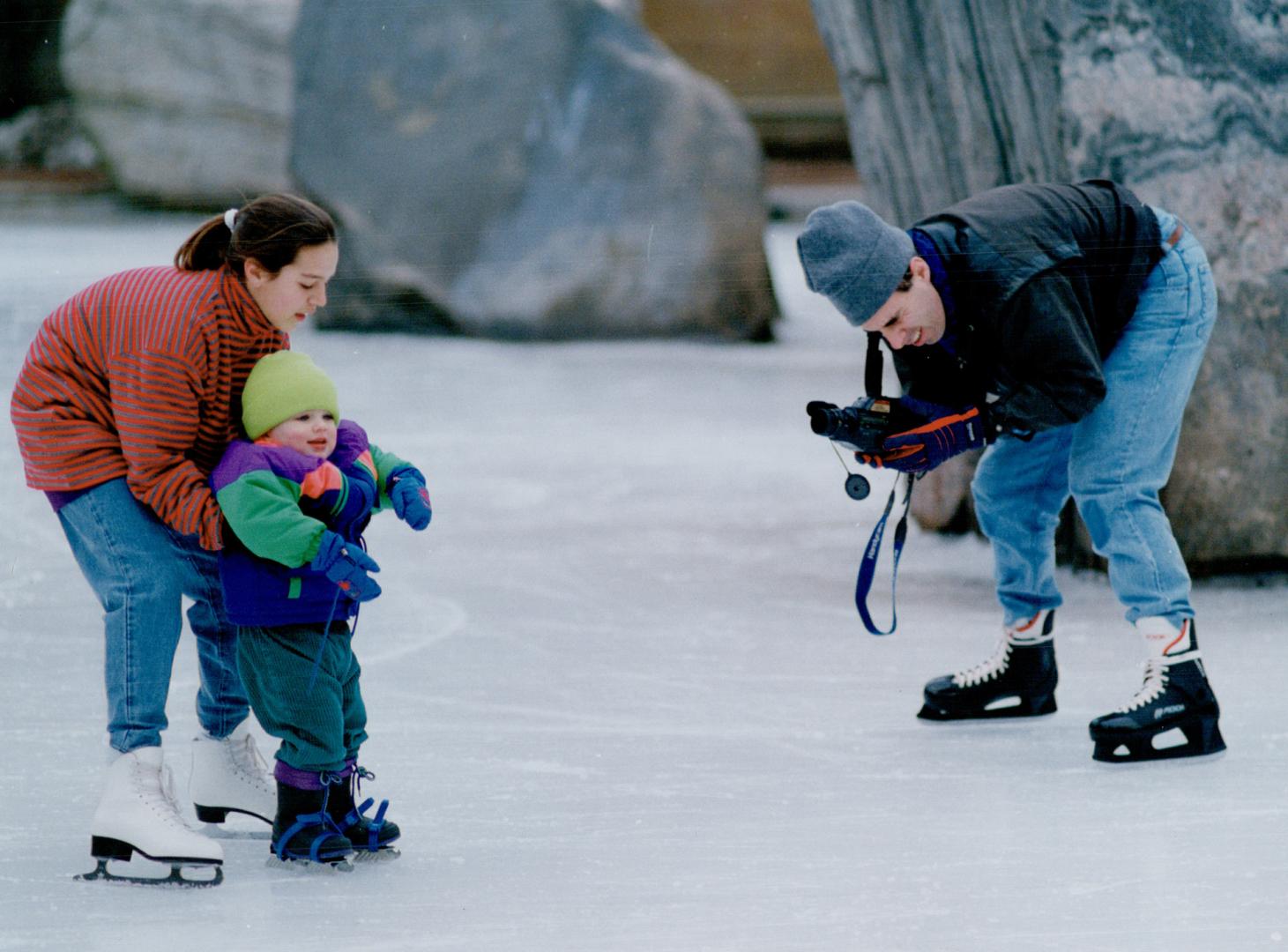 Say cheese: Doug Geidart, below, was capturing the moment his son Alan, 2, took to skates on video with friend Sarah Beltrami assisting at the Ryerson rink