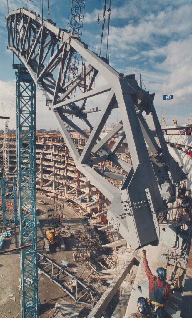 Dome's roof raised sky high. Workers and cranes position a huge steel truss into place as installation of the SkyDome's retractable roof began yesterd(...)