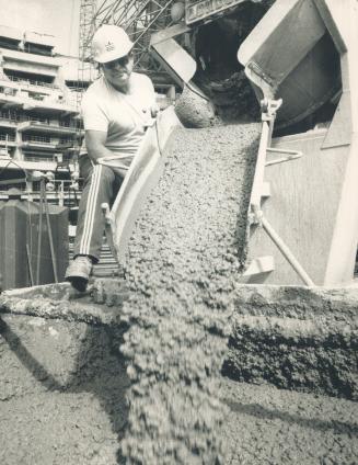 Concrete pours at Skydome: Truck operator Havey Stevenson pours fresh concrete from his mixer into a bucket at the downtown SkyDome site today, the first since May 9