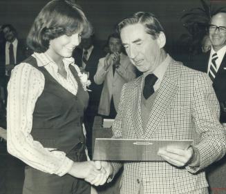 Winner of three gold medals in swimming events at the Commonwealth Games last month in Edmonton, Carol Klimpel is presented with a special plaque by M(...)