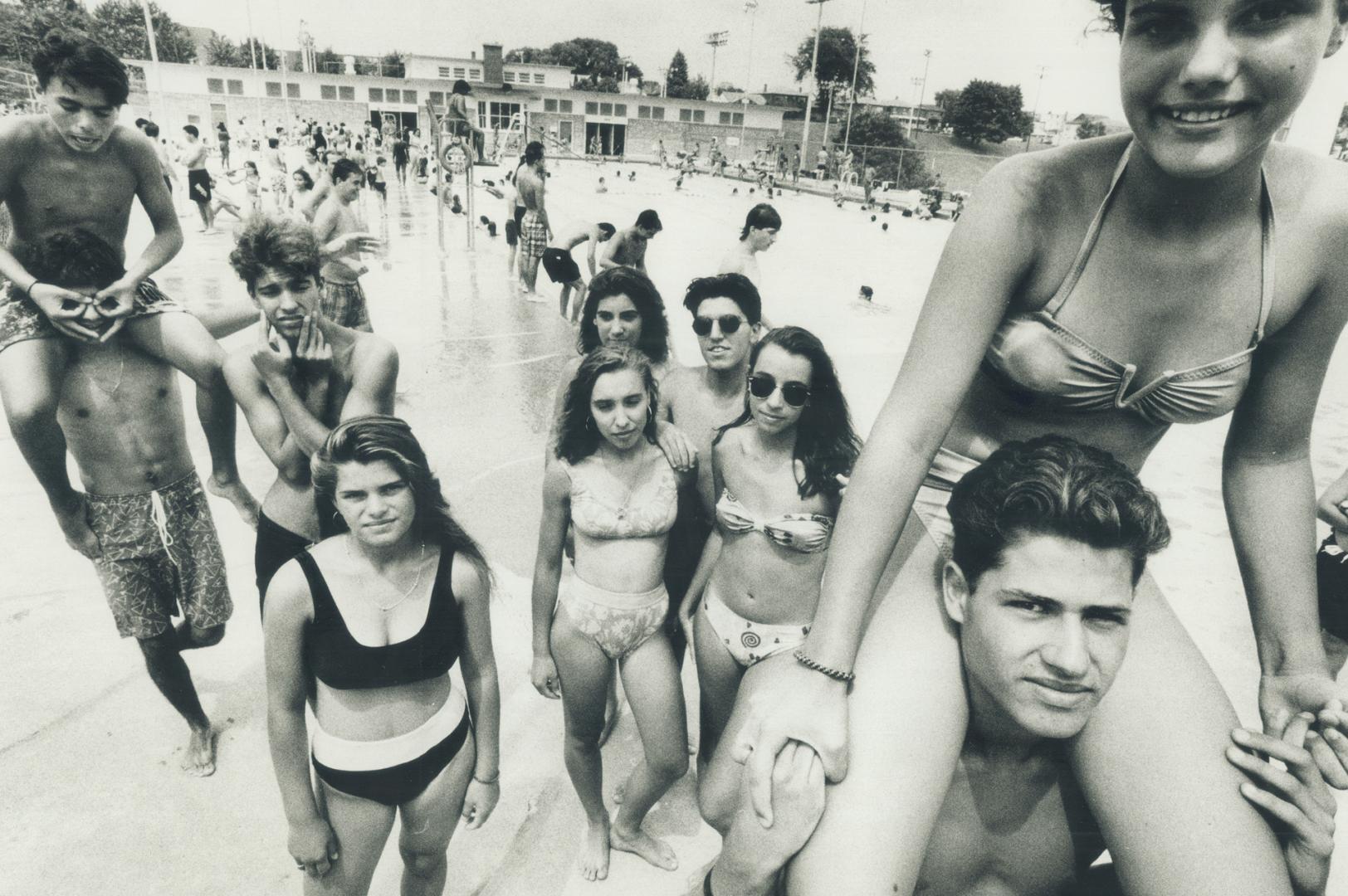 Manny Bandeira, 17, far right with Leslie Silva, 14, on his shoulders, hangs out with a large group of friends at Christie Pits pool