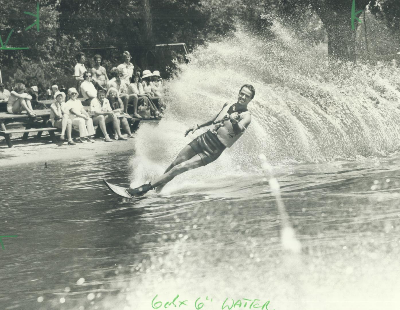 Dennis Riley kicks up a wall of water as he goes through his paces on way to winning senior men's slalom