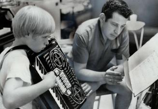 Concert Accordionist Lloyd La Vaux gives instructions to Ian Baird, 10, a Malton Iad who won two gold medals at last April's Peel Festival. [Incomplete]