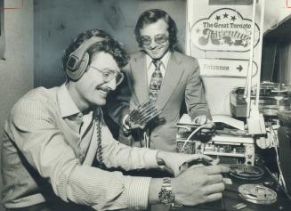 Producers Robert Pelton, foreground, and Stan Kates check sound track for film segment