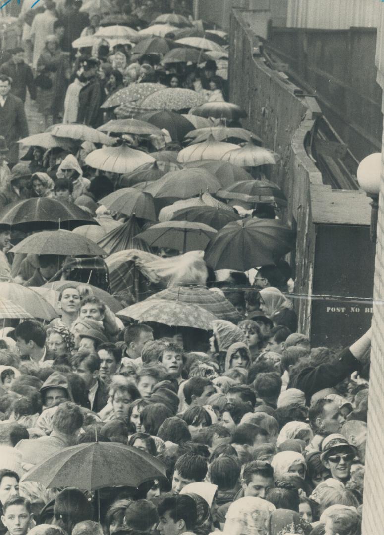 Let it rain would seem to be the motto of Beatles fans-many of them without umbrellas - as they lined up at Maple Leaf Gardens this morning when ticke(...)