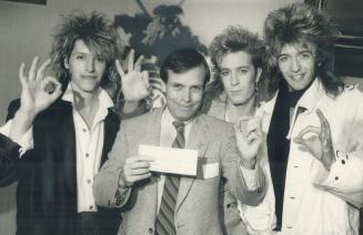 United Way chairman Gordon Cressy holds a cheque for $118,000 presented to him yesterday by Platinum Blonde members (from left) Sergio Galli, Kenney M(...)