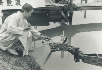 Toist priest Bill Wong performs the dim ching, - the eye-dotting ceremony - to prepare the six newly launched dragon boats for Toronto's fourth annual(...)