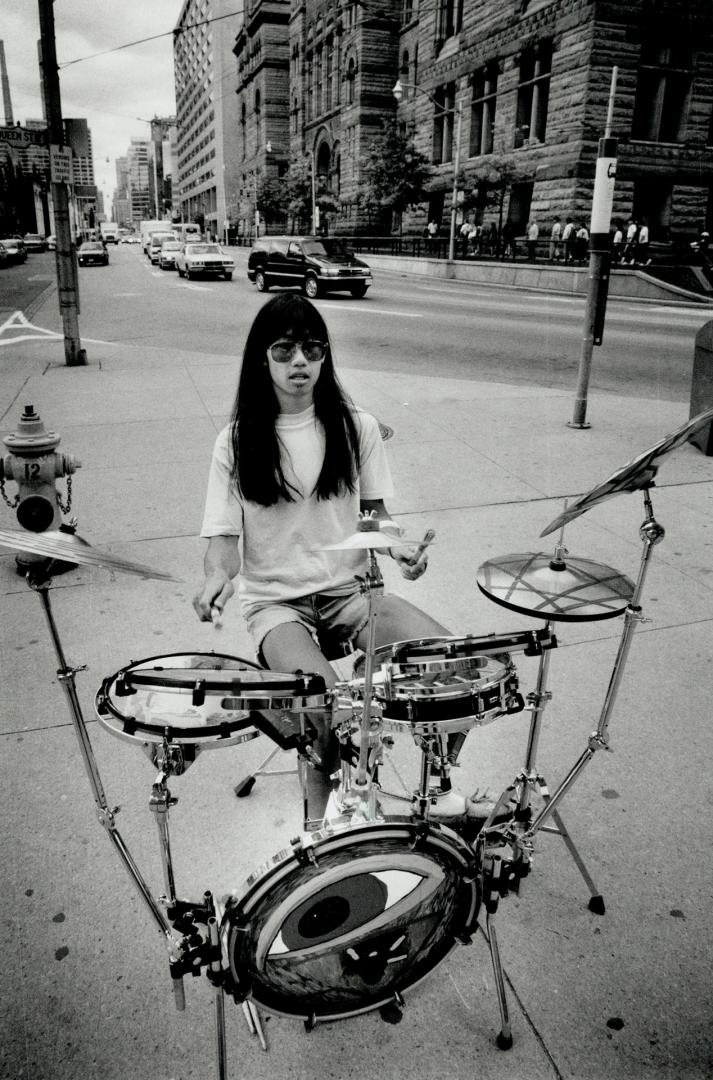 Drumming up business. David Lee pounds out a beat for passersby on the traffic island at Bay and Queen Sts. yesterday. He drums there occasionally, de(...)