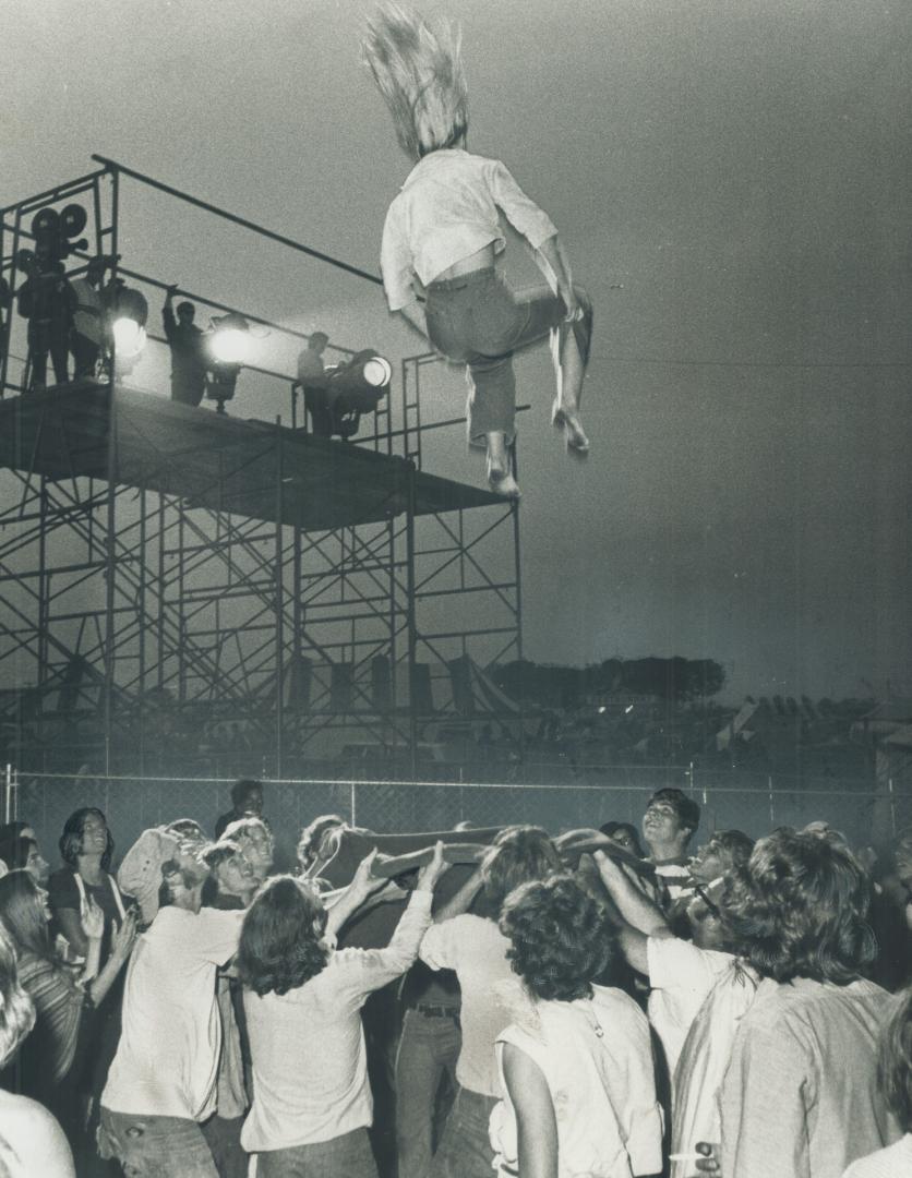 Flying high at Mosport, one of the fans at the rock music festival soars through the air, tossed from a blanket