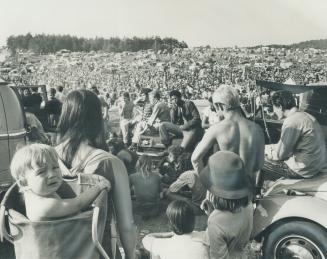 A Disenchanted rock fan, 11-month-old Chris Blakely obviously doesn't dig the sound at the Mosport rock festival as he rides in a papoose sling on the(...)