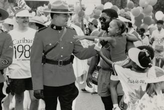 Caribana costume: Constable Curtis Hunt gets some attention from an admirer for his costume, the scarlet tunic of the RCMP, at Caribana parade yesterday