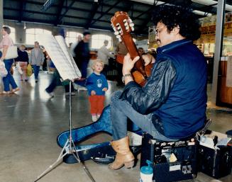 Old-time busker Edward De Silva woos the Saturday morning crowd near the sandwich bar at the St