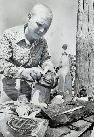 Beach-Dweller Peter, 30, an artist from Germany, finishes off a jade carving