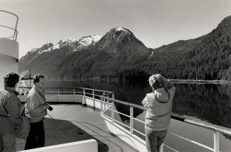 At lower left, passengers aboard the Queen photograph the mountains