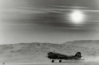 Mr. Justice David Marshall of the Northwest Territories Supreme Court takes the controls of DC-3 on a flight from Yellowknife to Rankin Inlet