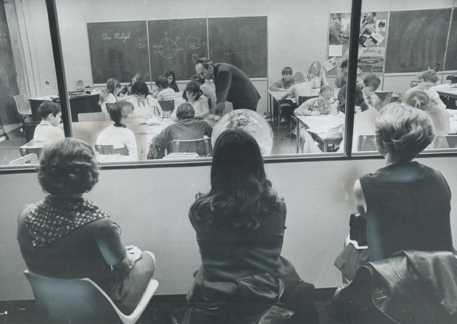 Teachers peep in on a special class, Three visiting teachers watch through a one-way window along the wall of a special demonstration classroom in Eto(...)