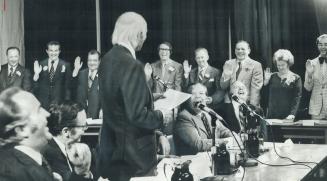 Lt.-Gov. W. Ross MacDonald swears in the new Halton Regional Council last night in Central High School, Burlington. After the inaugural meeting, the c(...)