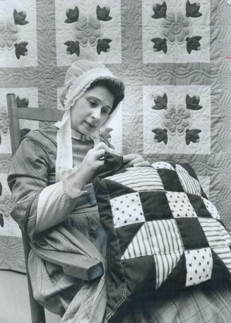 Gibson house shows its stuff, In pioneer costume, Katherine Barnes applies finishing touches to a pillow that will be part of a handicraft exhibit of (...)