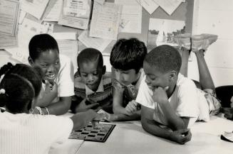 Study break: Karline Taylor, back to camera, and, from left, Kevin Cumberbatch, Randy Mills, Tariq Osman and Norm Mills play checkers