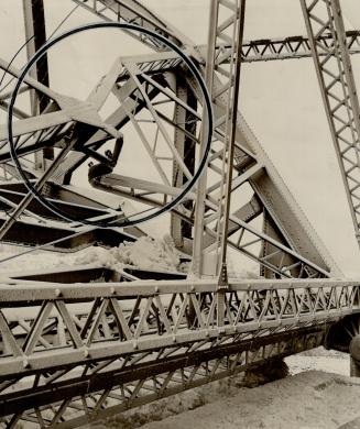 The tremendous pressure of ice floes buckled the huge bridge girders shown in the circle