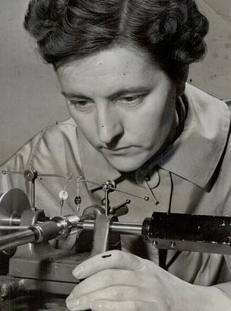 Tools to finish the job. This young lady performs the delicate task o fmeasuring the pitch of screw threads in the gauge-testing laboratories