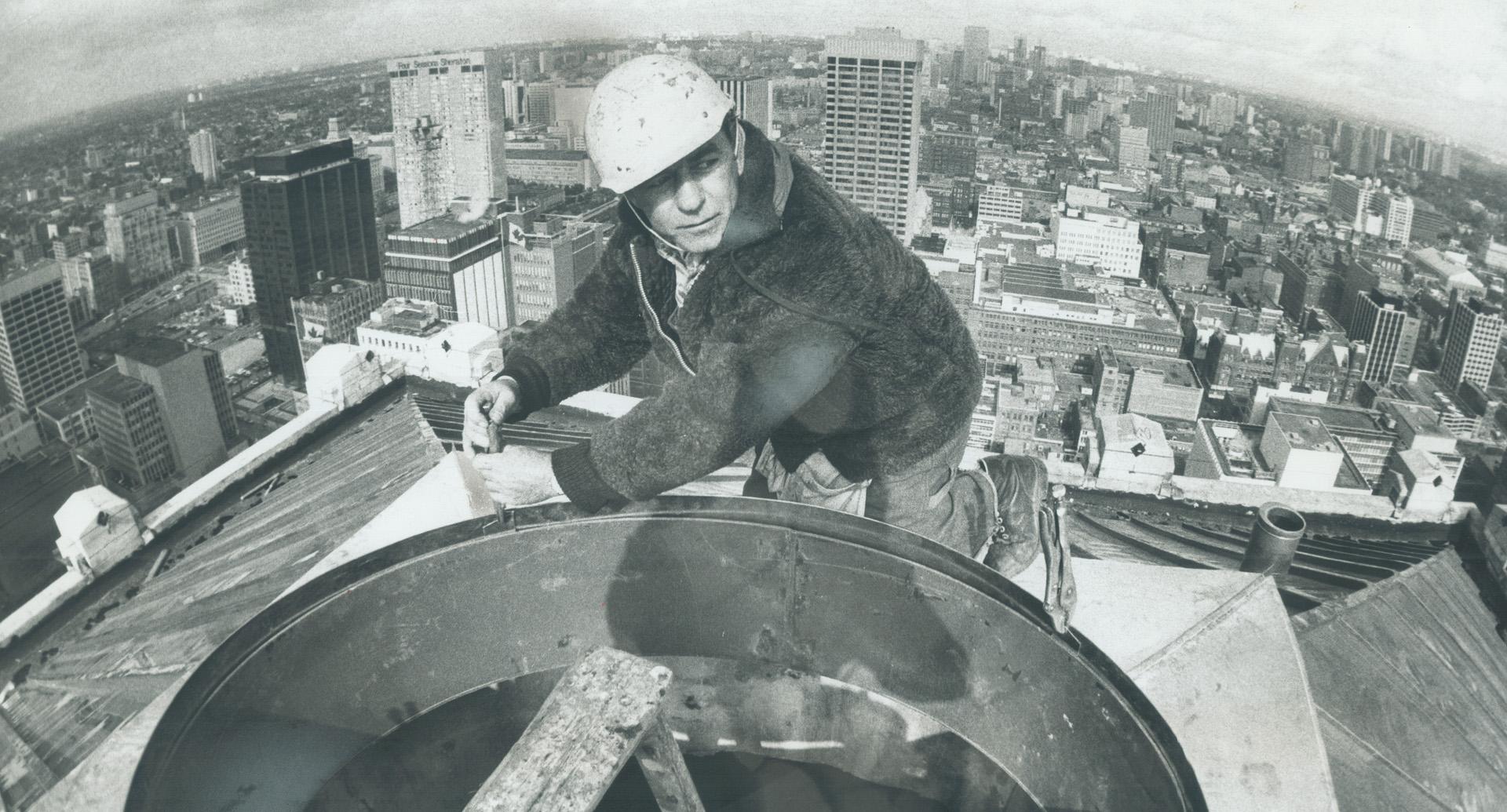 On top of the old Bank of Commerce Building-now to be called Commerce Court North-is sheet metal worker Steve Horvath