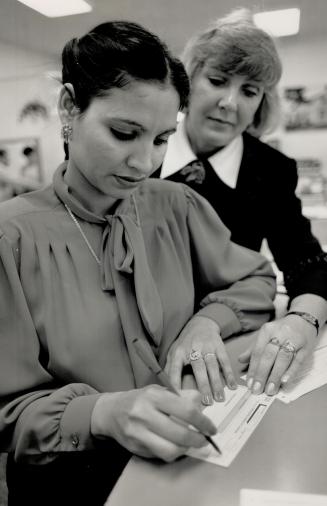 On the job: Jasbir Rai, left, is an adult student working on one of the Royal Bank's customer service representative programs, which is co-ordinated by Heather Sandrin