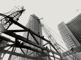 Trussed up- crane swings part of a steel truss into place at the Royal Bank Ontario head going up on King St