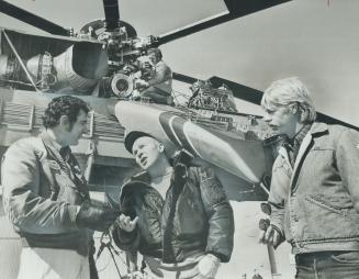 These three pilots are the men who fly Olga, the giant sikorsky S-64E helicopter being used to erect the 335-foot antenna on top of Toronto's CN Tower(...)