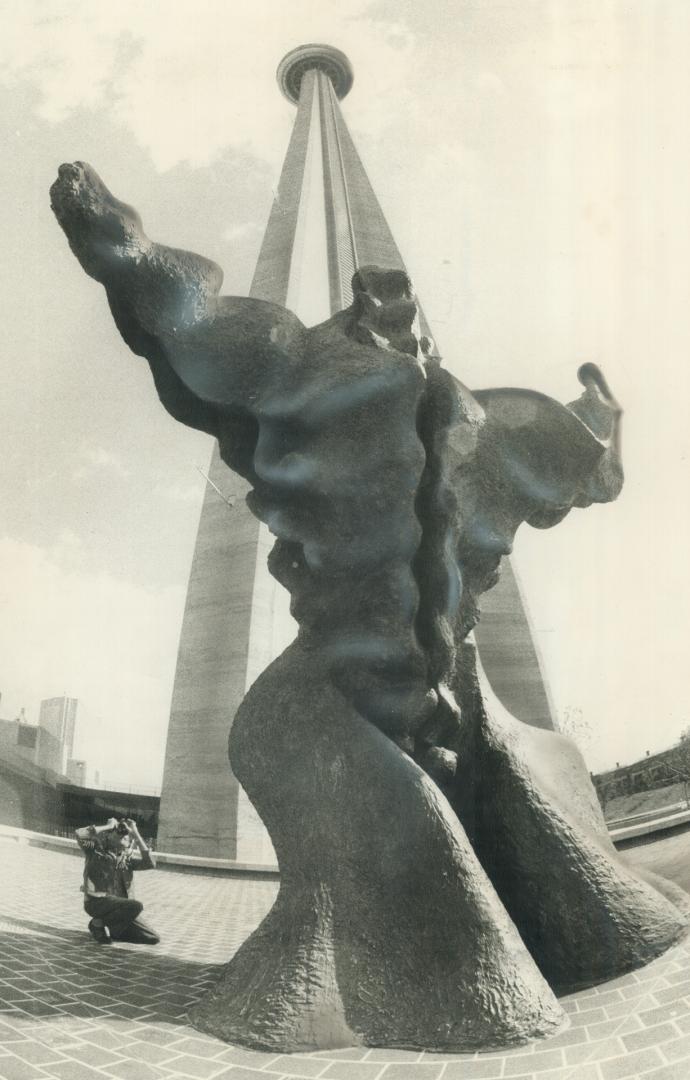 World's tallest free-standing statue? The 1,815-foot-high CN Tower appears to dwindle in the back-ground, viewed from this angle behind teh gigantic s(...)