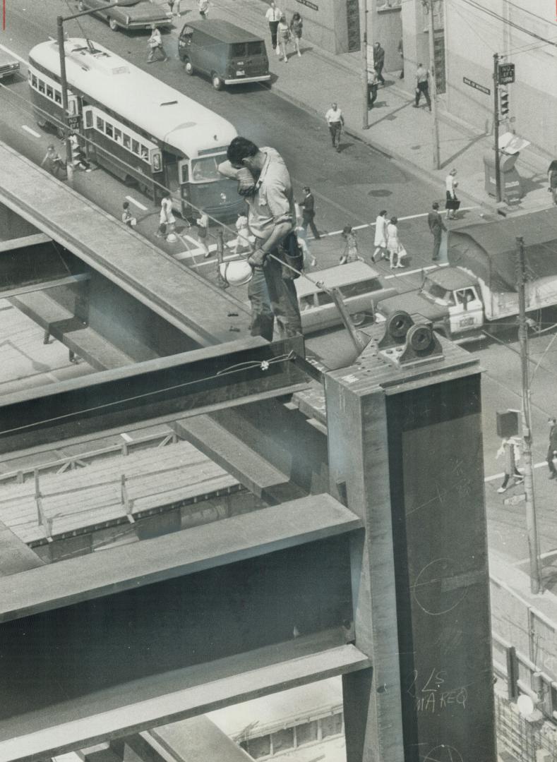 Man, there's a long way to go. A steel rigger pauses to wipe his brow on the big Commerce Court project, now seven storeys above street with 50 more t(...)