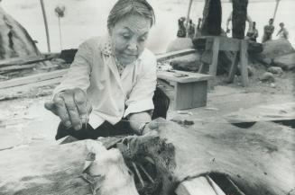 65-year-old Akinisi Nuvalinga sews seal skins for a kayak