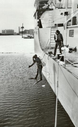 Going down: A scuba diver leaps into the open water from the ship in Toronto Harbor that serves as an underwater training centre -- even in the coldest of winter weather