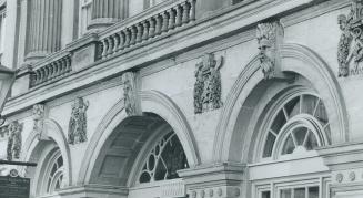 Stone faces of river gods guard the arches above the main entrance of St