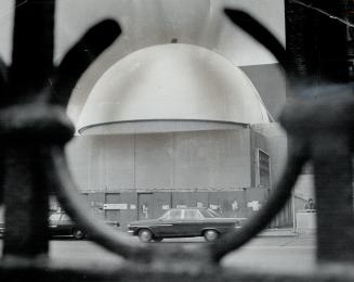 April 28, Heavy timber framing which supported the plastic cocoon is cleared away and planetarium's big dome beside the Royal Ontario Museum emerges f(...)