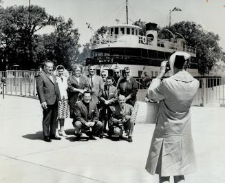 Snapping the snapper: Mrs. Hugh Murray of Montreal is photographed as she snaps a group of fellow Simpson's Quarter Century Club members after returni(...)